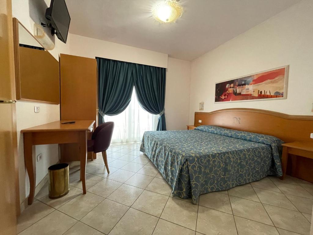 une chambre avec un lit, un bureau et une fenêtre dans l'établissement Roses Hotel, à Roseto degli Abruzzi 46 autres photos