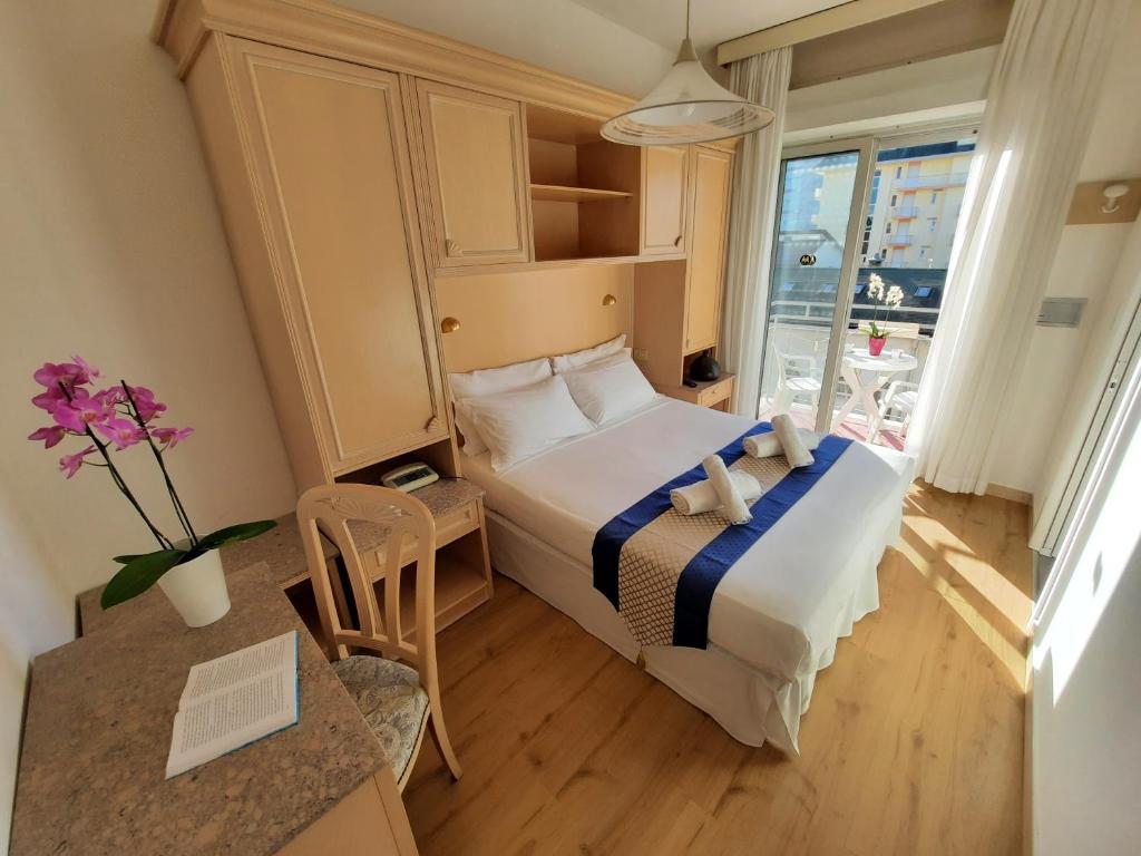 une petite pièce avec un lit et une fenêtre dans l'établissement Hotel Margherita, à Lido di Jesolo