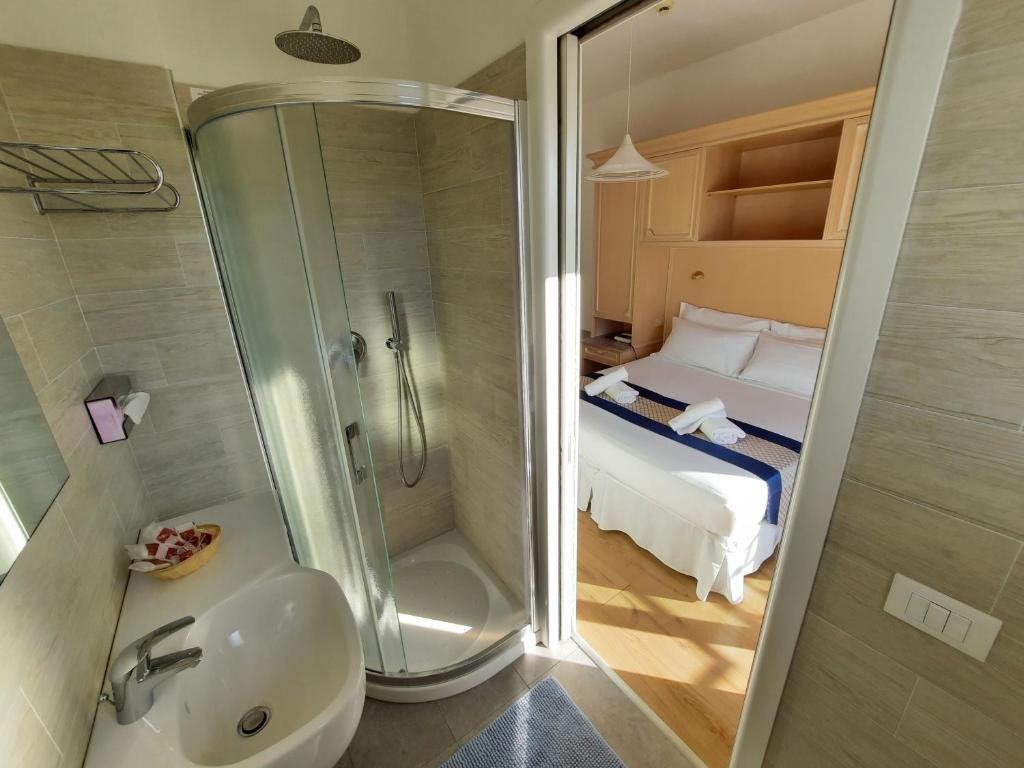 une salle de bain avec une douche et un lavabo et un lit dans l'établissement Hotel Margherita, à Lido di Jesolo 94 autres photos