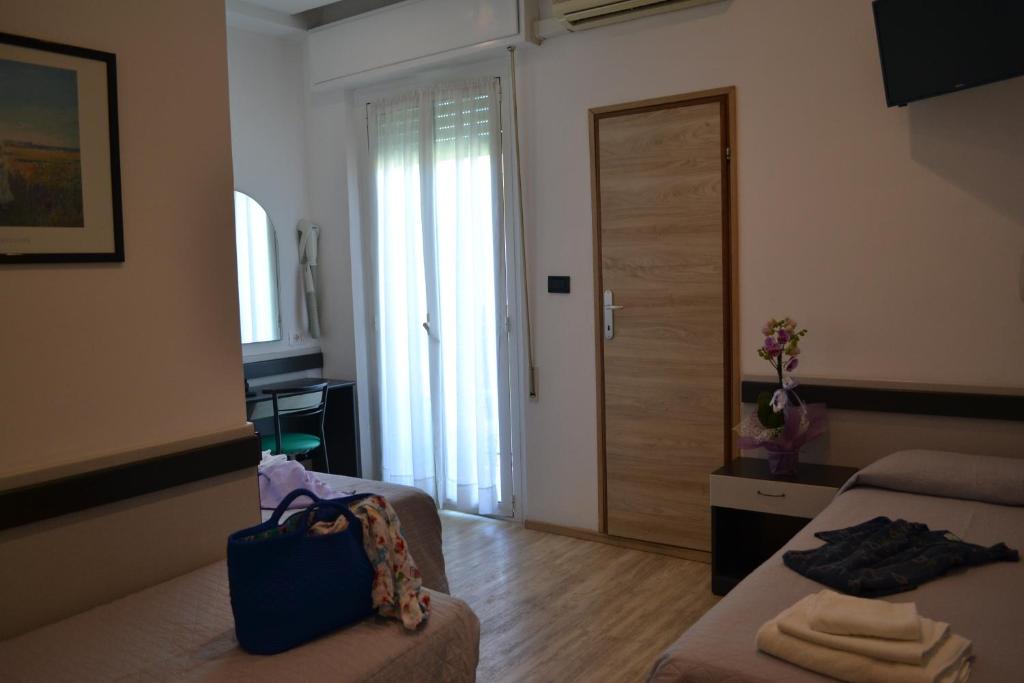 - un salon avec un canapé et une porte coulissante dans l'établissement Hotel Tre Stelle, à Rimini