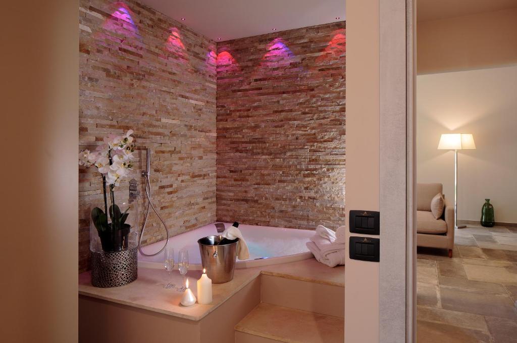 une salle de bain avec un mur de briques et une baignoire dans l'établissement Perugia Vecchia Relais, à Deruta