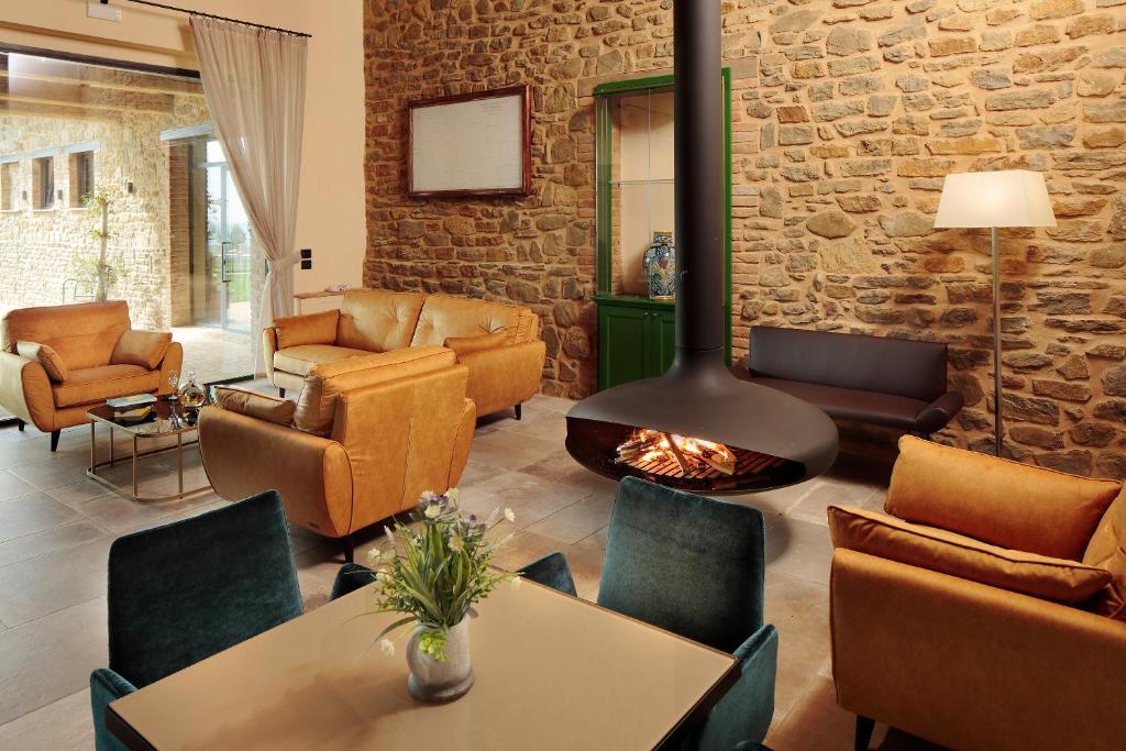 - un salon avec une cheminée, une table et des chaises dans l'établissement Perugia Vecchia Relais, à Deruta