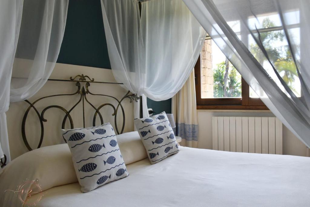 une chambre avec un lit blanc avec des oreillers et une fenêtre dans l'établissement Villa Palmetto, à Forte Village