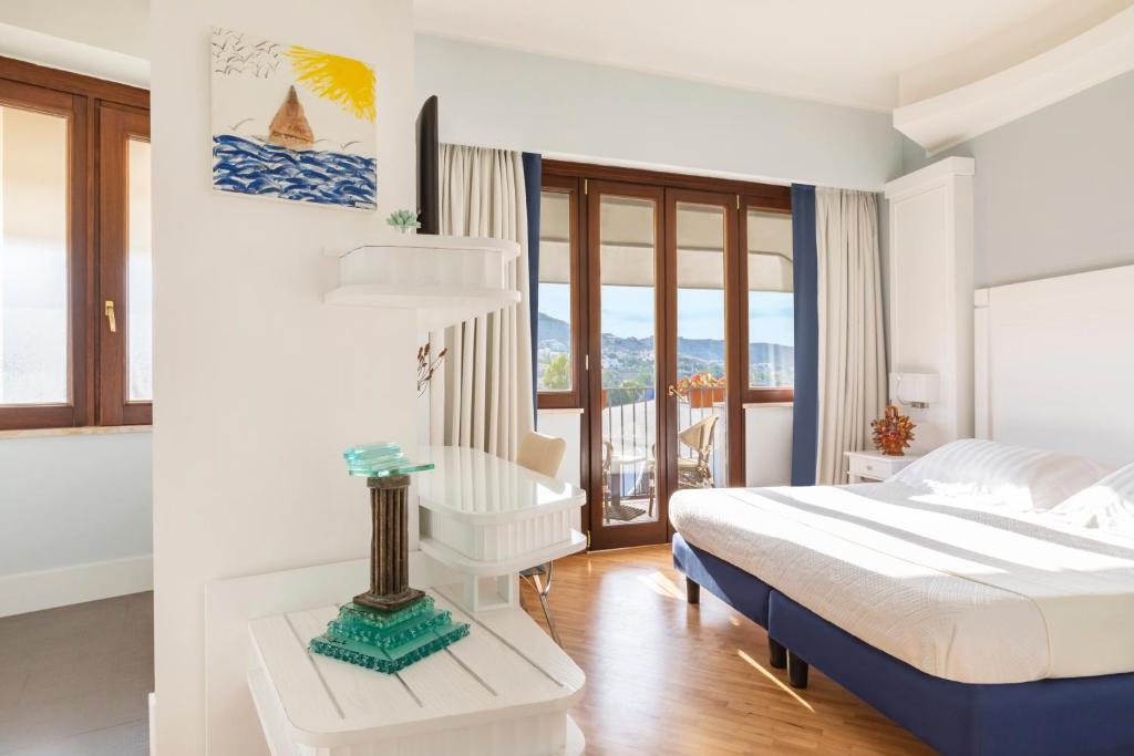 une chambre blanche avec un lit et un balcon dans l'établissement Hotel Lido degli Scogli, à Crotone