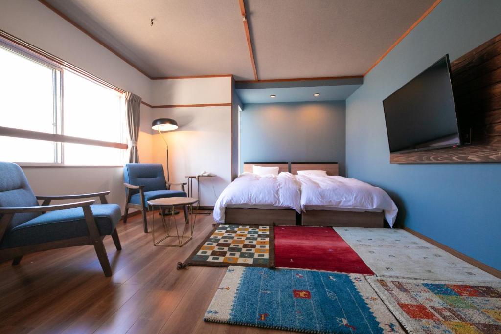 - une chambre avec un lit, une télévision et un tapis dans l'établissement Kunisakisou, à Beppu 69 autres photos
