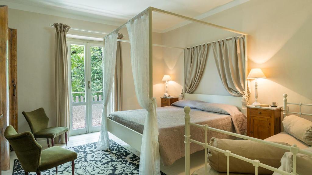 une chambre avec un lit à baldaquin et une chaise dans l'établissement VILLA LA CORTE 6, Emma Villas, à Montecastrilli