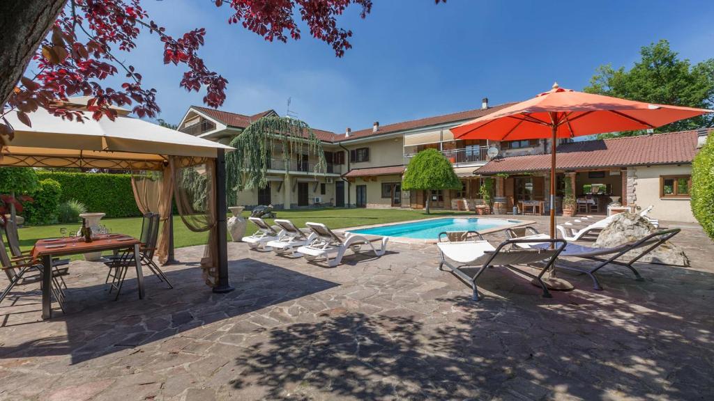 une terrasse avec des chaises et un parasol ainsi qu'une piscine dans l'établissement Villa Miki 10, Emma Villas, à Bruno