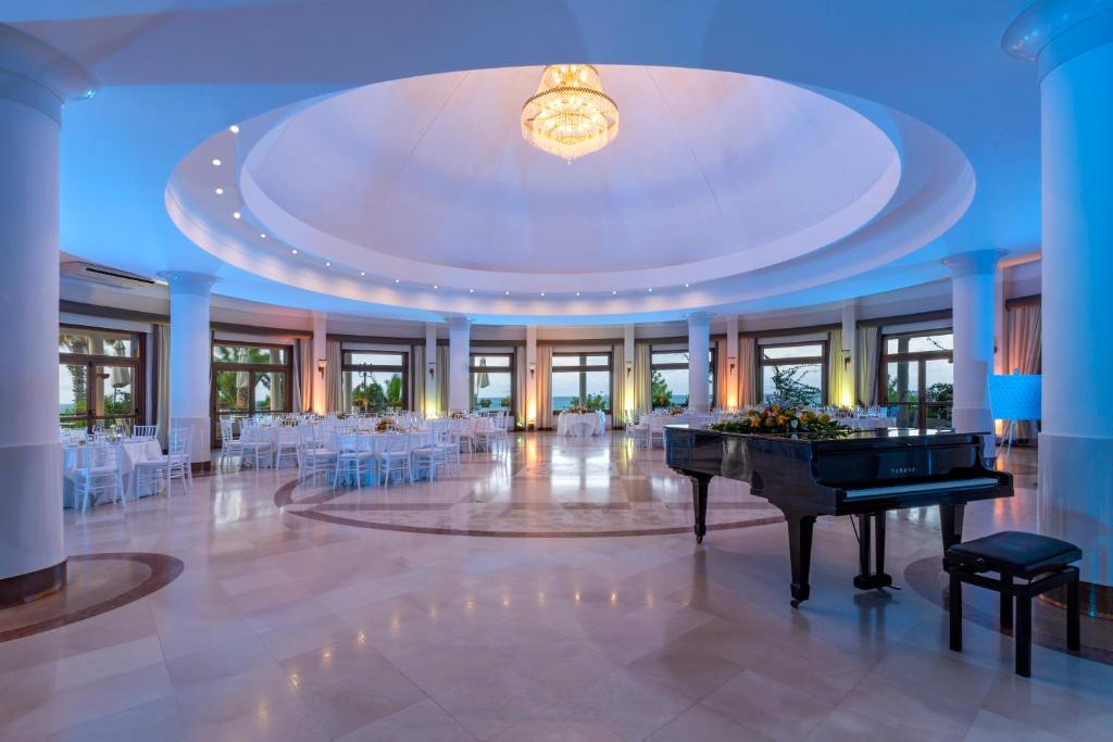 une grande salle de banquet avec un piano à queue dans une chambre dans l'établissement Hotel Lido degli Scogli, à Crotone 40 autres photos