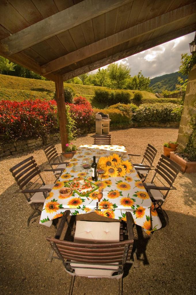 une table avec des tournesols assise sous un toit dans l'établissement Il Mulino - beautiful, family-friendly Tuscan villa with fenced pool, à Monterchi