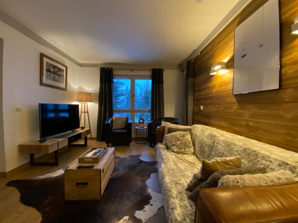un salon avec un canapé et une télévision dans l'établissement Superbe appt 2 chambres Arc 1950, à Arc 1950