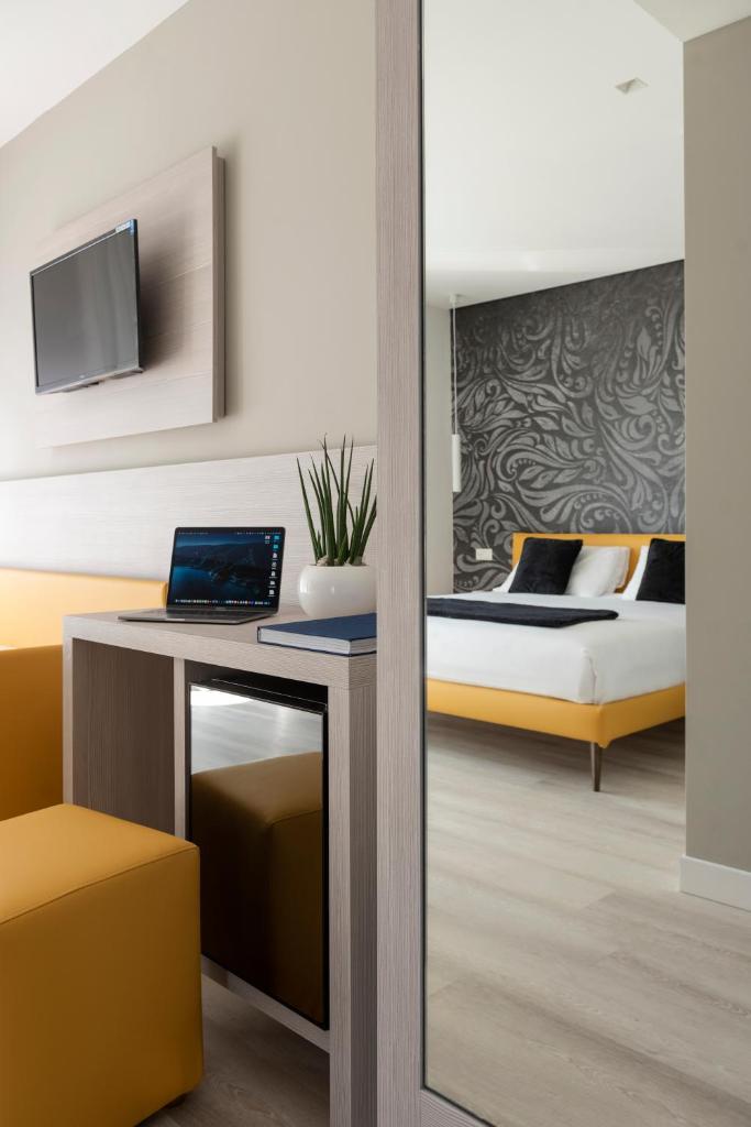 une chambre avec un lit et un bureau avec un ordinateur portable dans l'établissement Hotel Delle Rose, à Lido di Jesolo