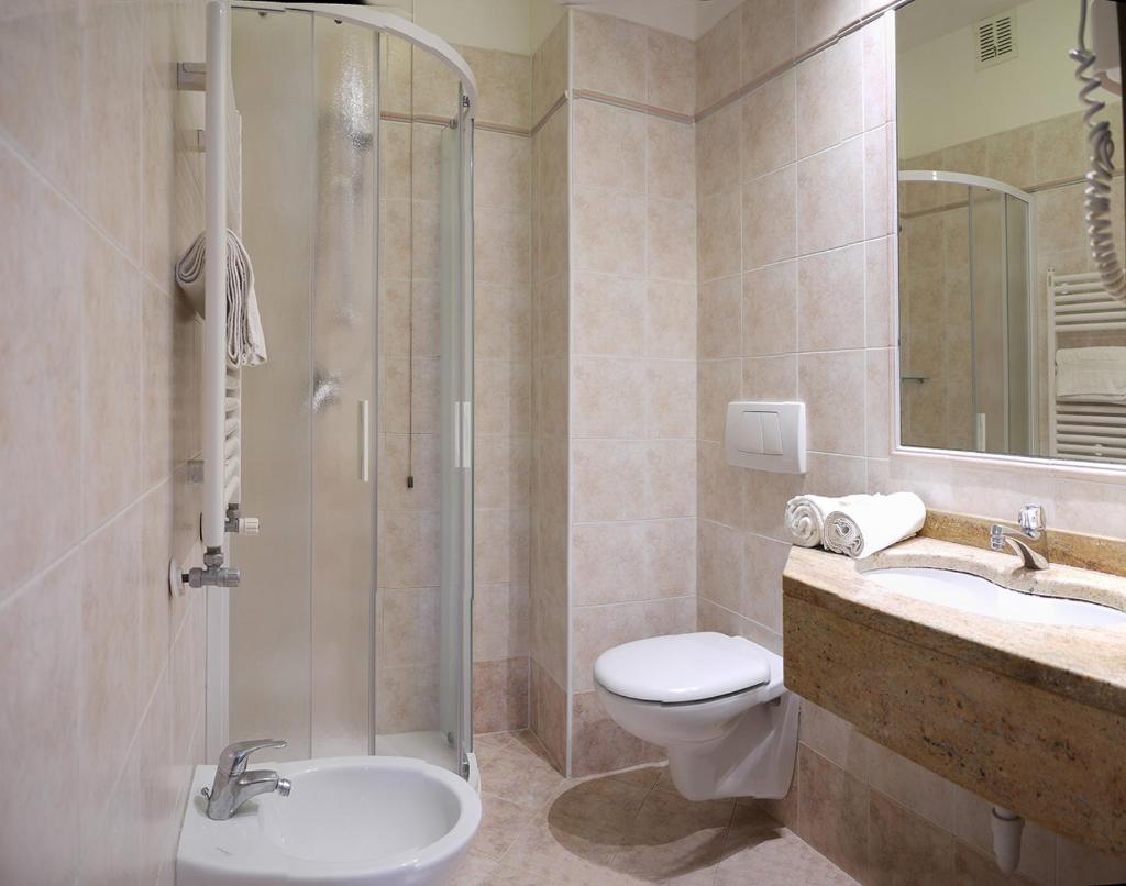 une salle de bain avec une douche, des toilettes et un lavabo dans l'établissement Hotel Alla Rotonda, à Lido di Jesolo