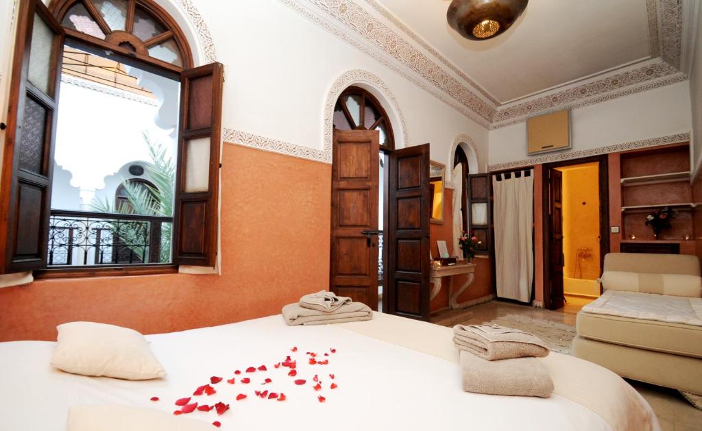 une chambre avec un lit avec des fleurs rouges dessus dans l'établissement Riad Elias & Spa, à Marrakech 37 autres photos