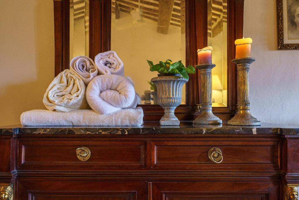 - une commode avec 2 serviettes et 2 bougies dans l'établissement Fattoria di Piantravigne Villa Storica del 600, à Case Malva