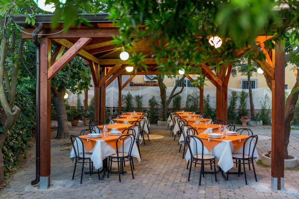 une rangée de tables et de chaises sous une pergola dans l'établissement Hotel Villa Susy, à Davoli