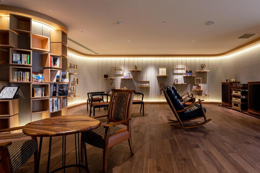 une bibliothèque avec des chaises, une table et des étagères dans l'établissement Shogetsu Grand Hotel, à Jozankei