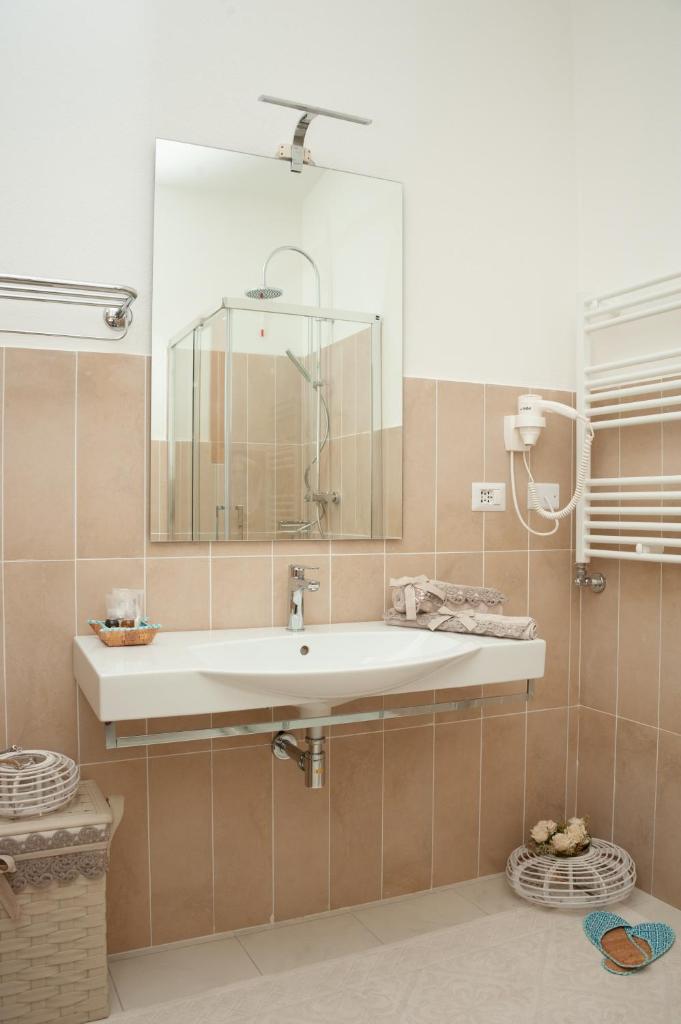 une salle de bain avec un lavabo et un miroir dans l'établissement GH Santina Resort & SPA, à Valledoria