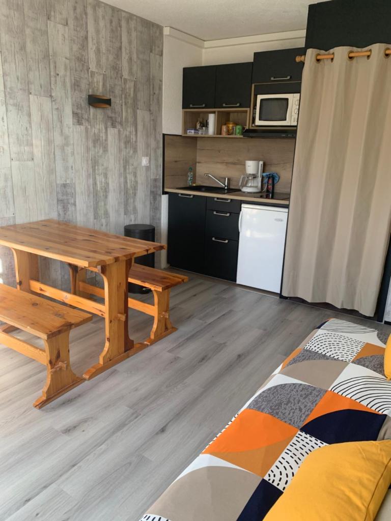 - une cuisine avec une table en bois dans une chambre dans l'établissement Studio cabine Piau-Engaly au pied des pistes, à Aragnouet