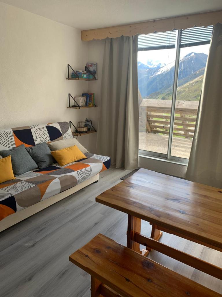 un salon avec un canapé, une table et une fenêtre dans l'établissement Studio cabine Piau-Engaly au pied des pistes, à Aragnouet