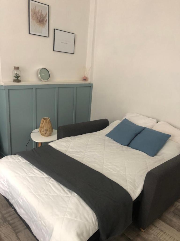 une chambre avec un grand lit avec des oreillers bleus dans l'établissement 11 Rue de Richelieu, à Cauterets