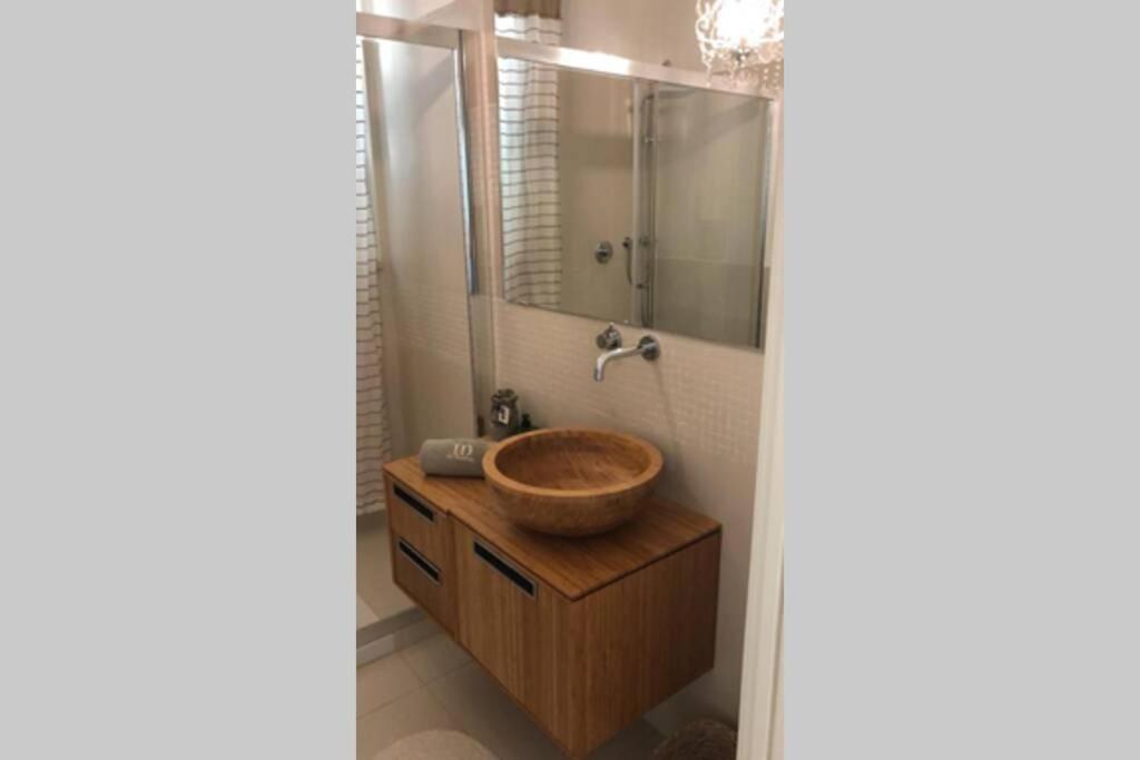 une salle de bain avec un lavabo en bois et un miroir dans l'établissement Luxury Villa Mariachiara, à Monopoli 18 autres photos