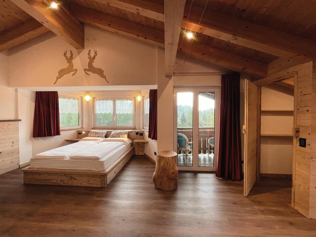- une chambre avec un grand lit et des fenêtres dans l'établissement Hotel Al Lago, à Lavarone