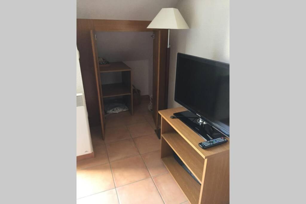 un salon avec une télévision sur une table en bois dans l'établissement T2 Bis, calme, plein centre de Luchon, avec balcon et garage, à Luchon