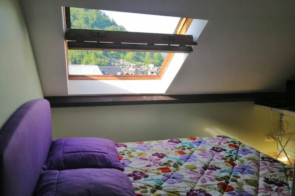 une chambre avec un lit et une fenêtre dans l'établissement T2 Bis, calme, plein centre de Luchon, avec balcon et garage, à Luchon