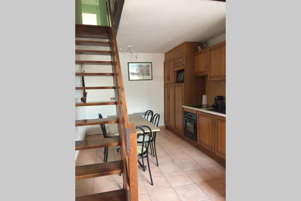 une cuisine avec un escalier en colimaçon et une table avec des chaises dans l'établissement T2 Bis, calme, plein centre de Luchon, avec balcon et garage, à Luchon
