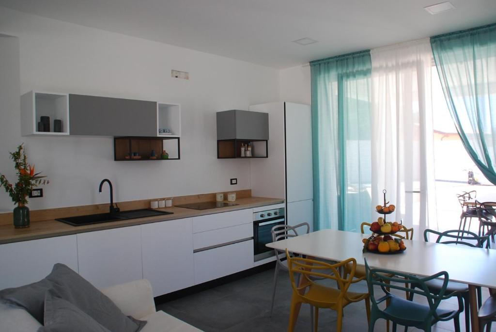 une cuisine et une salle à manger avec une table et des chaises dans l'établissement La Perla Bianca, à Porto Palo