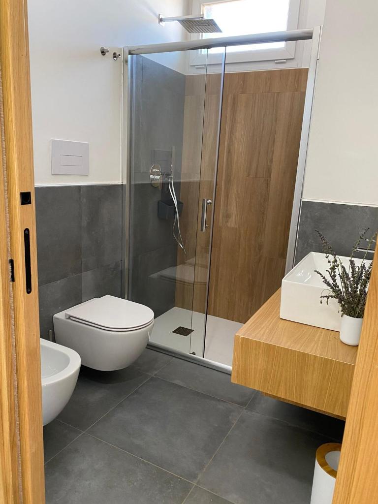 une salle de bain avec une douche, des toilettes et un lavabo dans l'établissement La Perla Bianca, à Porto Palo 48 autres photos