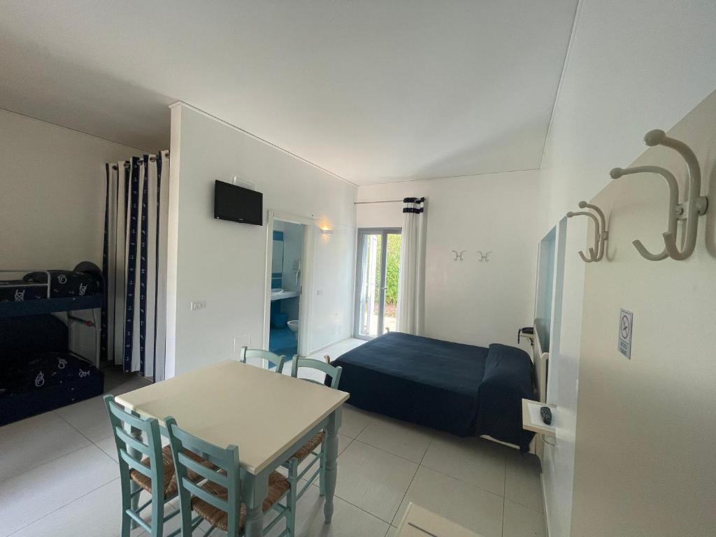 une chambre avec un lit, une table et des chaises dans l'établissement Baia Sangiorgio Hotel & Beach Club, à Bari