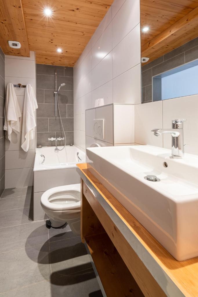 une salle de bain avec un lavabo, des toilettes et une baignoire dans l'établissement Le Rookie Mountain, au Grand-Bornand