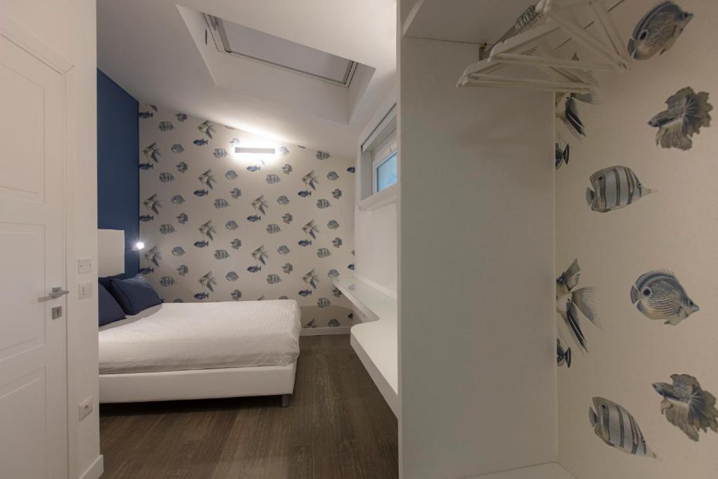 - une petite chambre avec un lit et un mur avec des crânes dans l'établissement La Porta sulla spiaggia Casa vacanze, à Su Forti