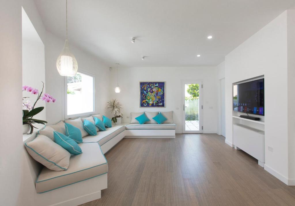un salon avec un canapé et une télévision dans l'établissement La Porta sulla spiaggia Casa vacanze, à Su Forti