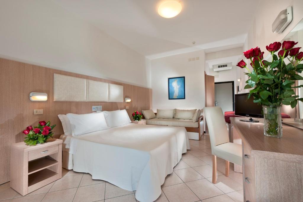 une chambre d'hôtel avec un grand lit et un salon dans l'établissement Hotel Cormoran, à Cattolica