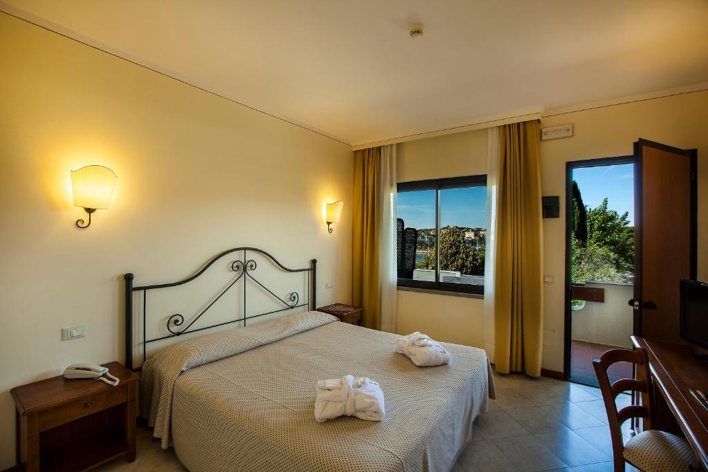 une chambre d'hôtel avec un lit avec des serviettes dessus dans l'établissement Hotel Airone isola d'Elba, à Portoferraio