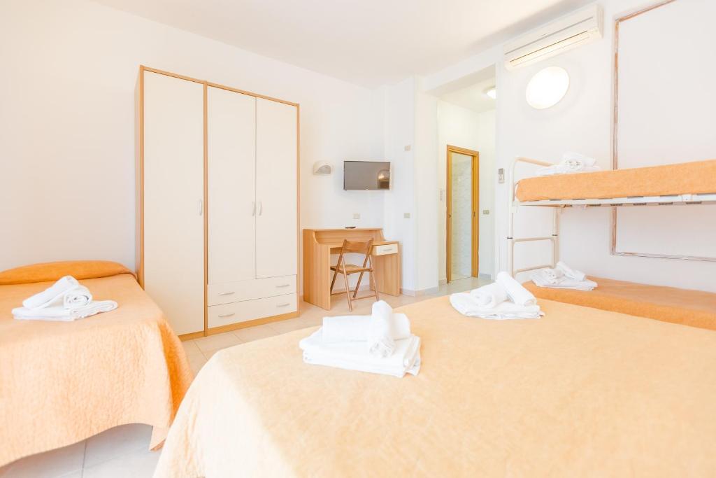 une chambre avec deux lits avec des serviettes dessus dans l'établissement Hotel Marylise, à Rimini