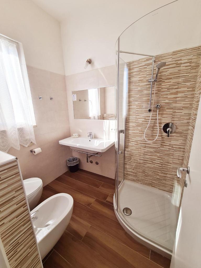 une salle de bain avec une douche, des toilettes et un lavabo dans l'établissement Hotel Camelia, à Rimini