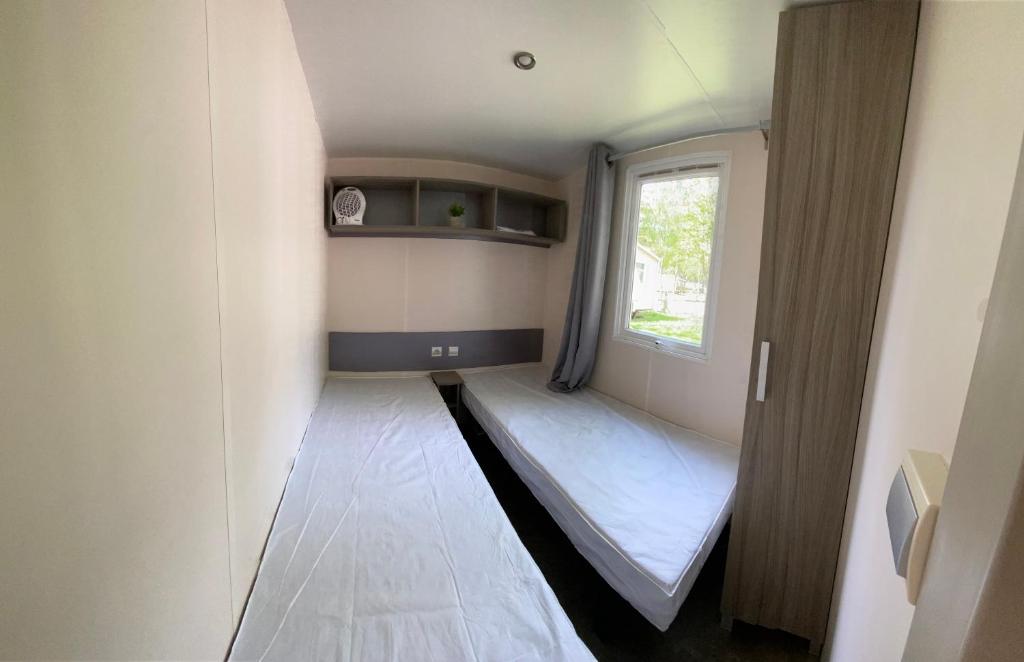 une petite pièce avec un lit et une fenêtre dans l'établissement Mobil home climatisé 6 personnes dans camping 3* Tohapi a BOOFZHEIM, à Boofzheim
