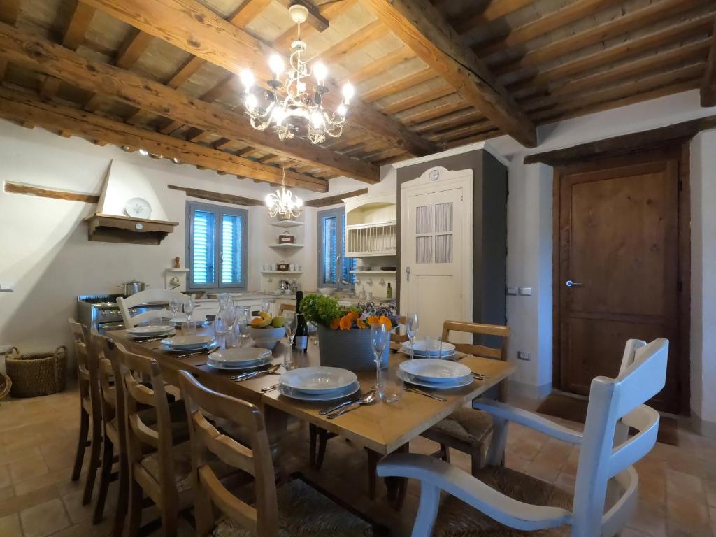 une salle à manger avec une grande table et des chaises en bois dans l'établissement Casale Iris, à Belmonte Piceno