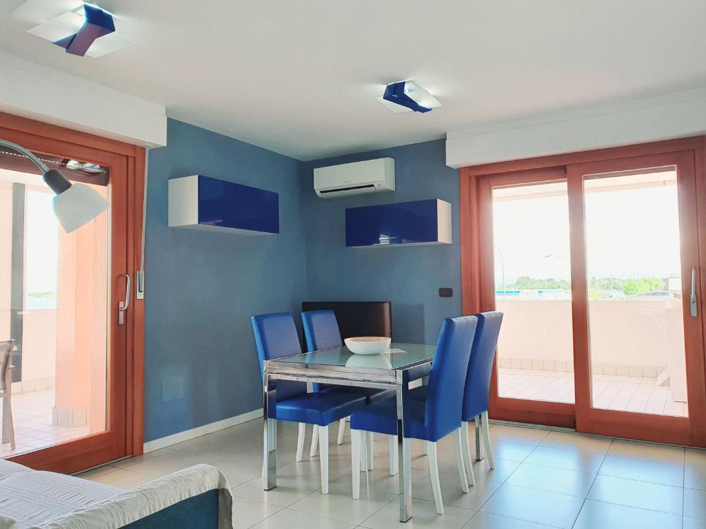 une salle à manger avec une table et des chaises bleues dans l'établissement Aparthotel Capitol, à Grado