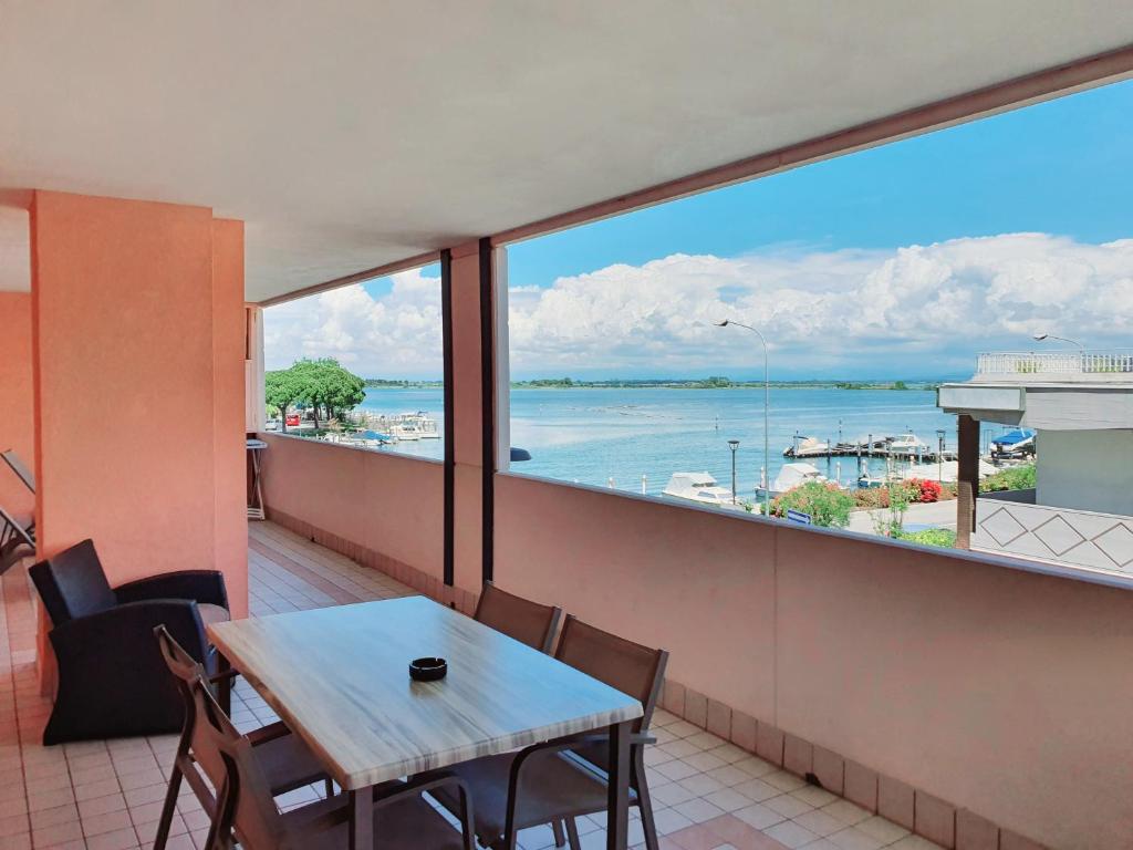 un balcon avec une table et une vue sur l'eau dans l'établissement Aparthotel Capitol, à Grado