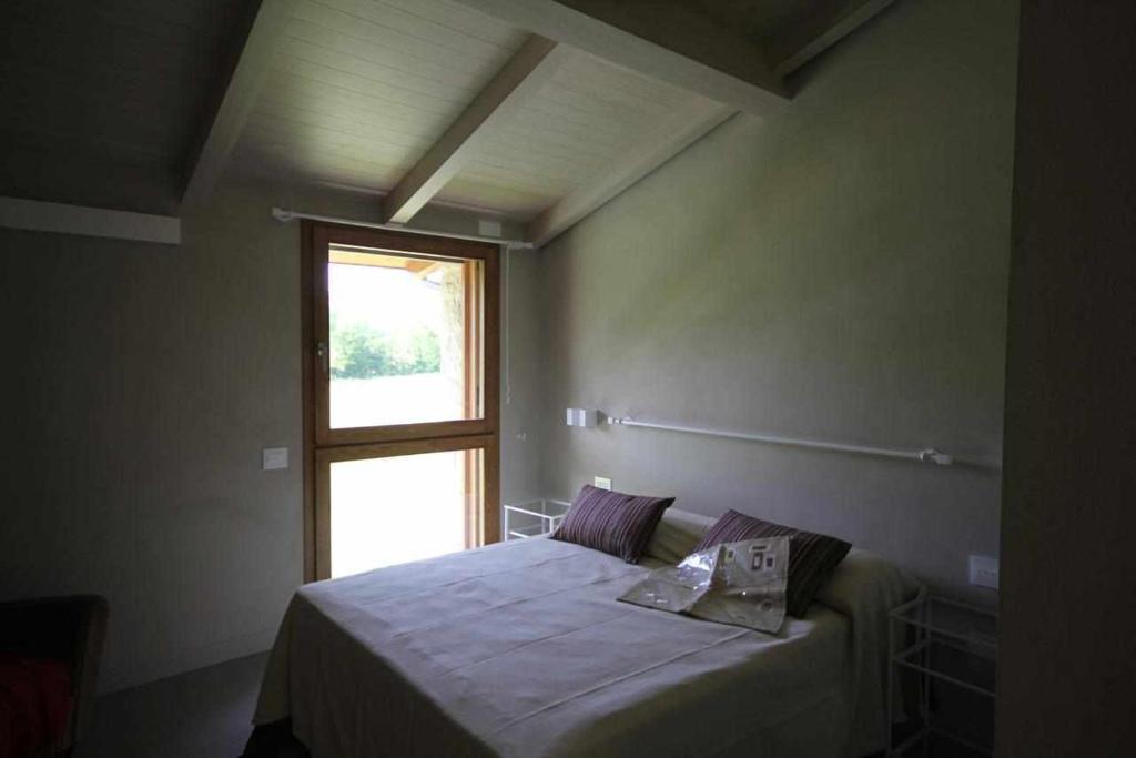 une chambre avec un lit et une fenêtre dans l'établissement Molino dei Ciliegi - Splendida villa in Umbria, à San Venanzo