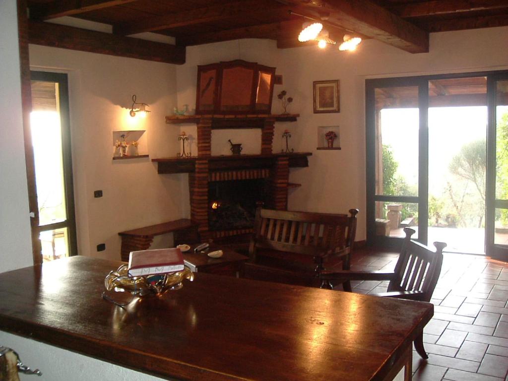 - un salon avec une table en bois et une cheminée dans l'établissement AgriHouse Orvieto, à Morrano