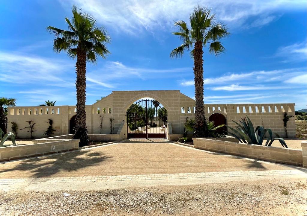 un bâtiment avec deux palmiers devant lui dans l'établissement Tropical Palm Villa, à Monopoli