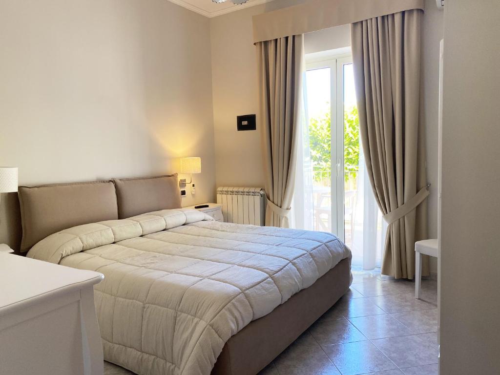 une chambre avec un lit et une grande fenêtre dans l'établissement Hotel Ristorante Colleverde, à Santa Maria di Castellabate