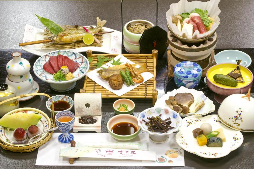 une table recouverte de assiettes et de bols de nourriture dans l'établissement Kosenkaku Yoshinoya, à Totsukawa