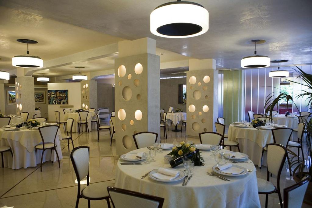 une salle de banquet avec tables et chaises et nappes blanches dans l'établissement Hotel Ristorante Cavaliere, à Scario