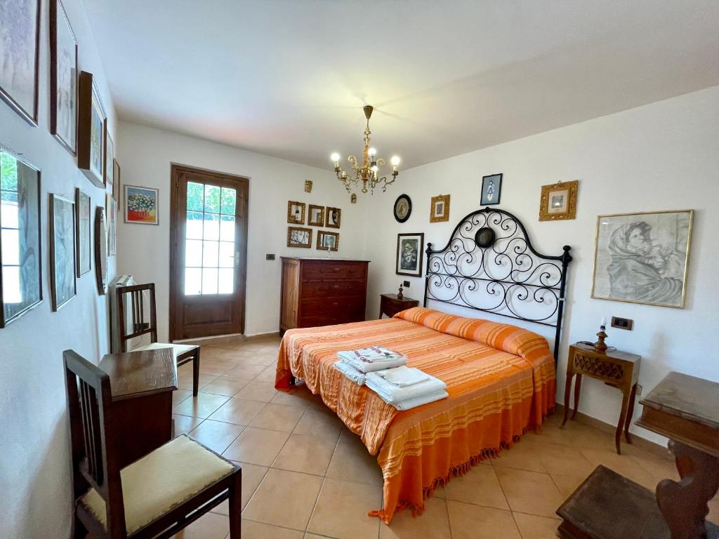une chambre avec un lit avec un couvre-lit orange dans l'établissement Casa Bianca Villa pool with sea view, fenced garden, barbecue by ToscanaTour, à Castellina Marittima